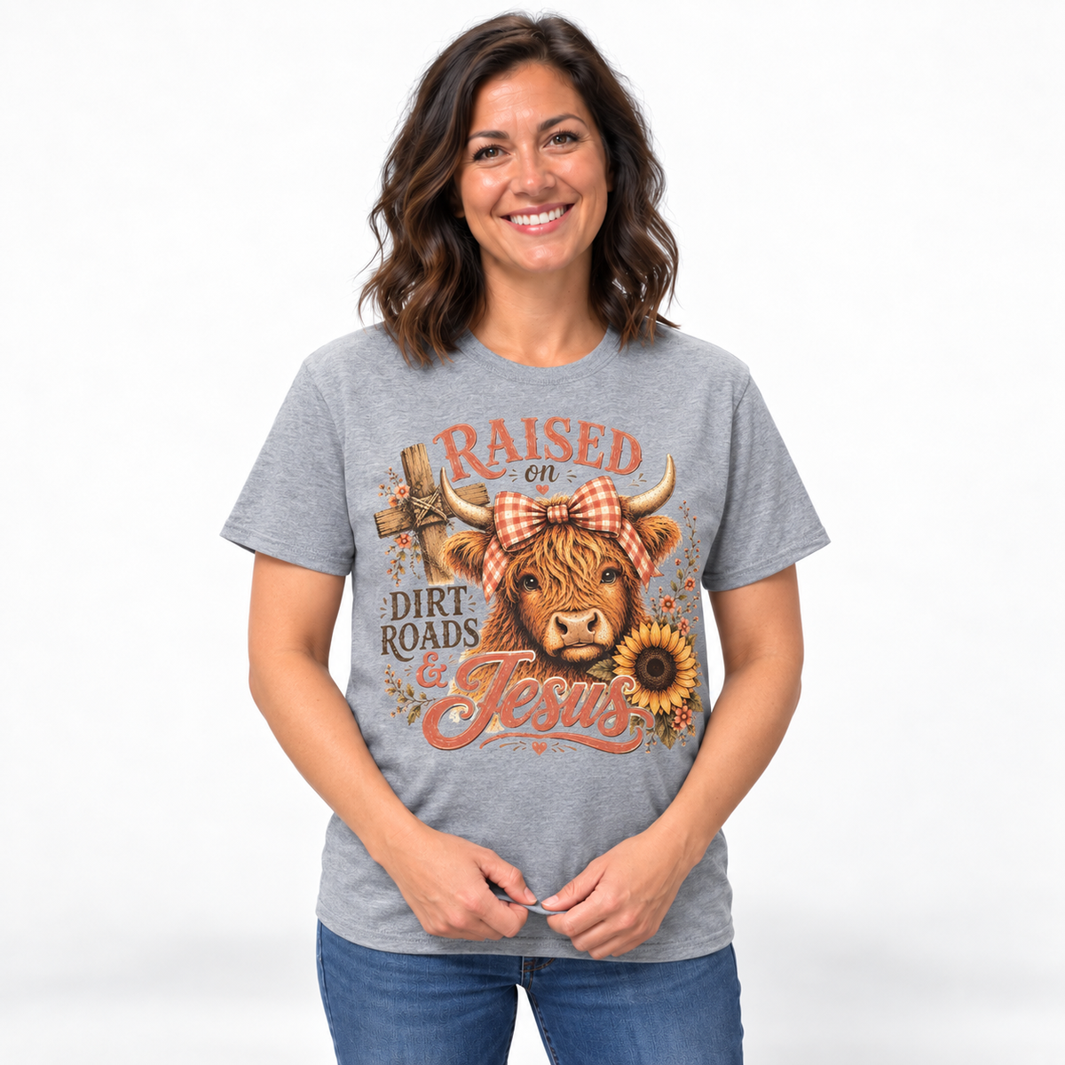 Model wearing Raised on Dirt Roads and Jesus Highland cow shirt